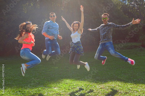 Group of friends having fun and jumping at idyllic day