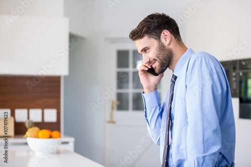 Businessman talking on mobile phone in kitchen
