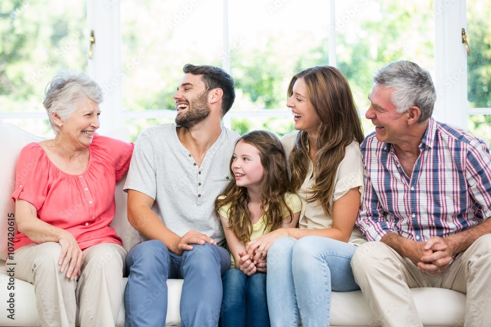 Family laughing while sitting on sofa Family laughing while sitting on sofa