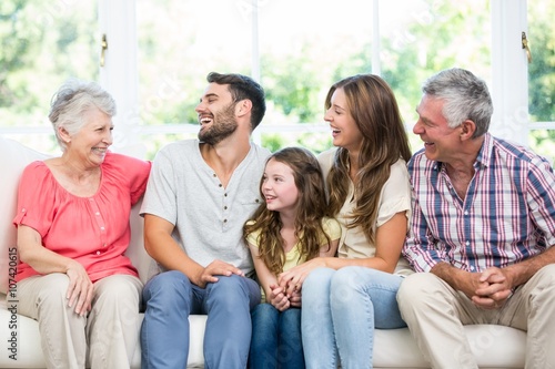 Family laughing while sitting on sofa