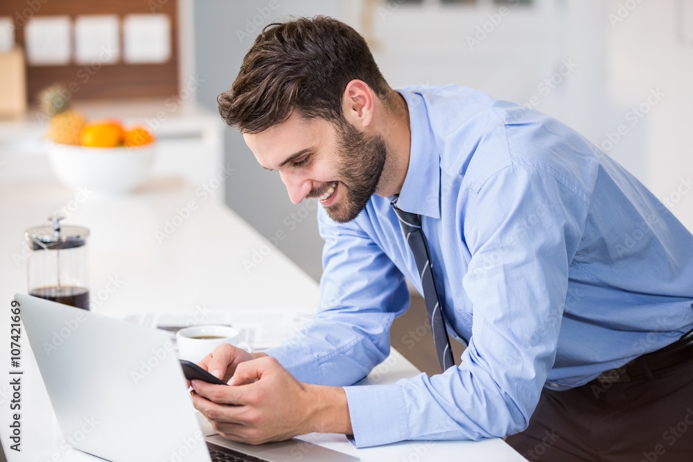 Happy man using laptop and phone 
