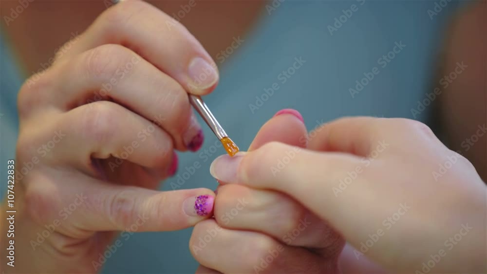 Apply thin layer of gel on fingernail close up Apply thin layer of gel on fingernail close up