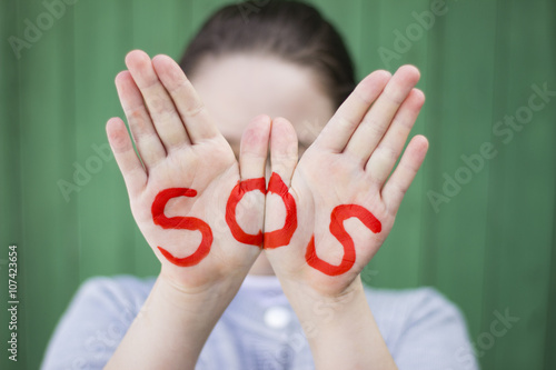 Foto The inscription on the hands of SOS, help sign - SOS sign