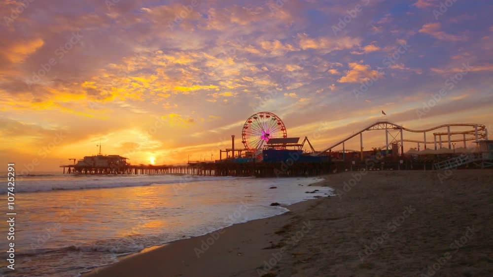 Santa Monica California sunset on Pier Ferris wheel and reflection on beach wet sand Santa Monica California sunset on Pier Ferris wheel and reflection on beach wet sand