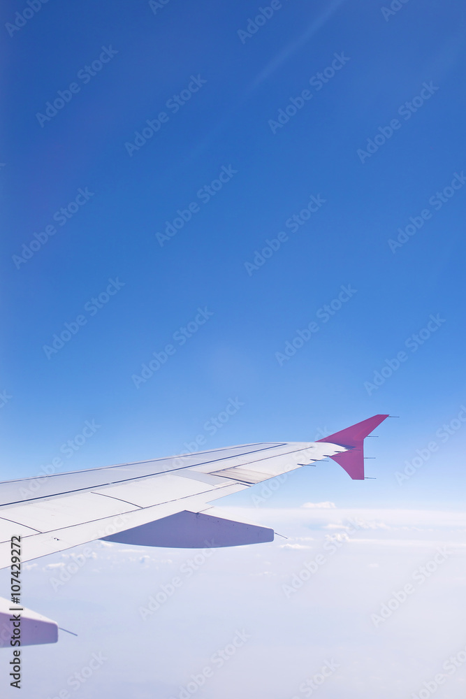 Wing aircraft against a background of blue sky and clouds. The view from the porthole Wing aircraft against a background of blue sky and clouds. The view from the porthole