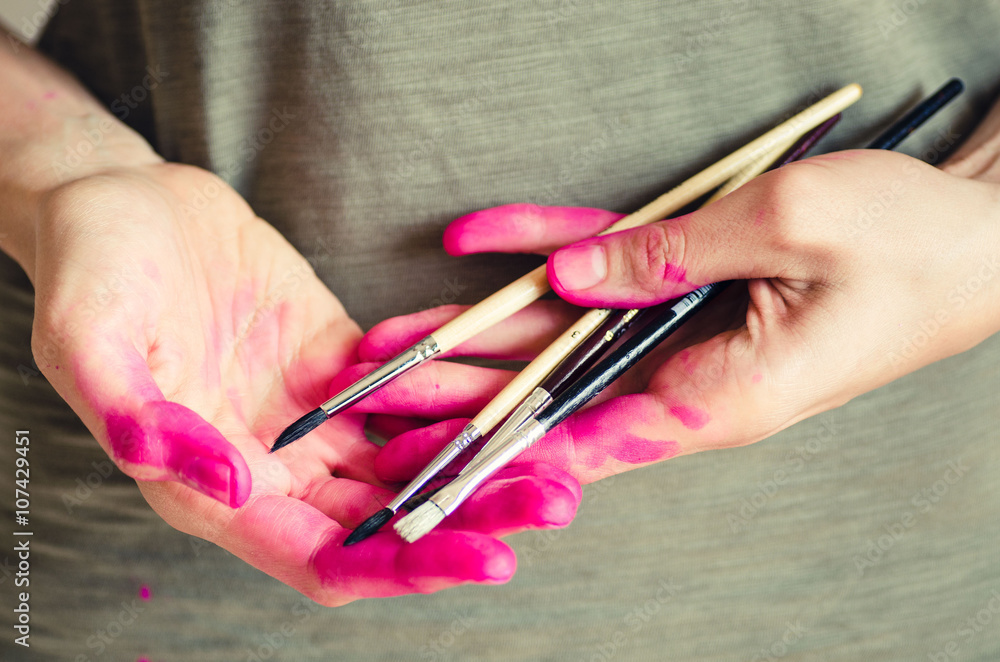 Female artist hands covered with pink paint Female artist hands covered with pink paint