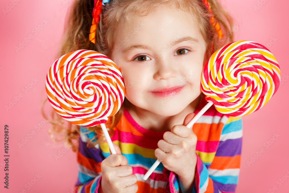 Studio portrait of a beautiful little girl with large Lollipop