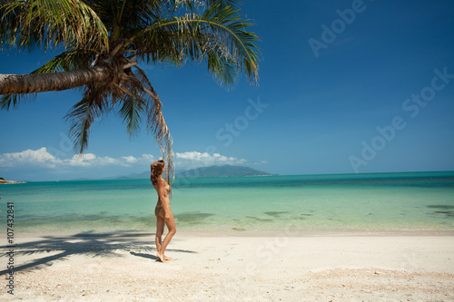 femme se promenant sur une plage paradisiaque
