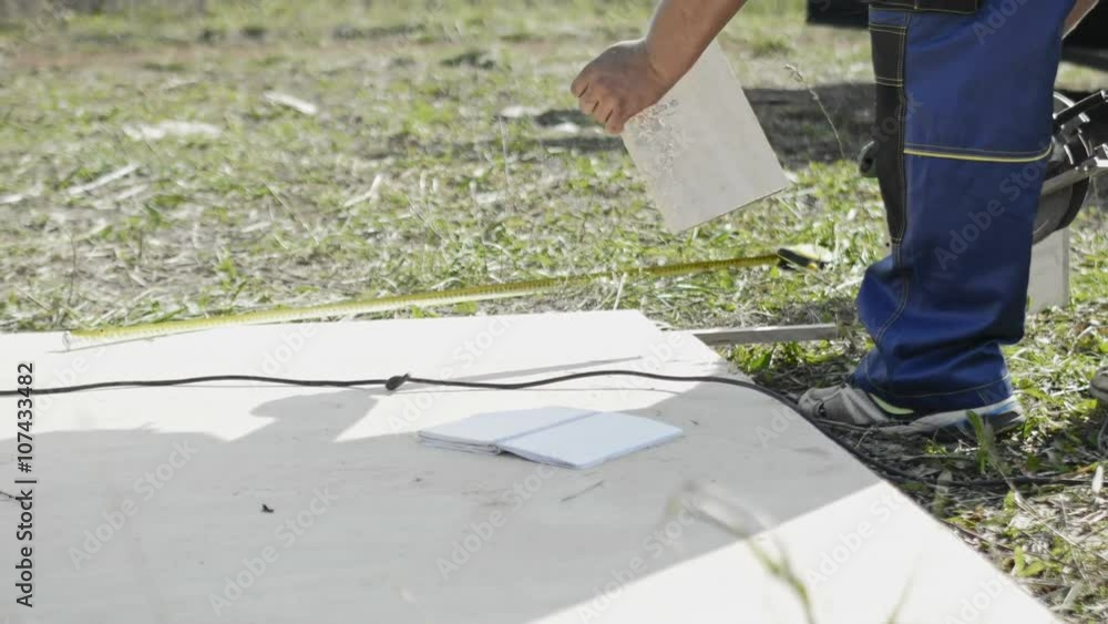 man cuts sheet of plywood at the construction site man cuts sheet of plywood at the construction site