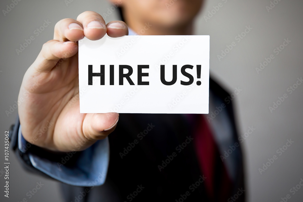 Businessman presenting 'Hire us' word on white card Businessman presenting 'Hire us' word on white card