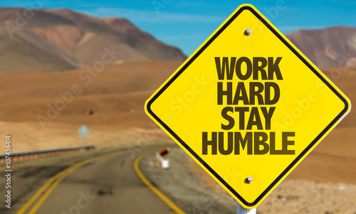 Work Hard Stay Humble sign on desert road photo