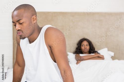 Young man sitting on bed after an argument