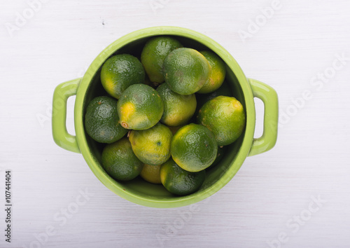 A green lemons on the bowl