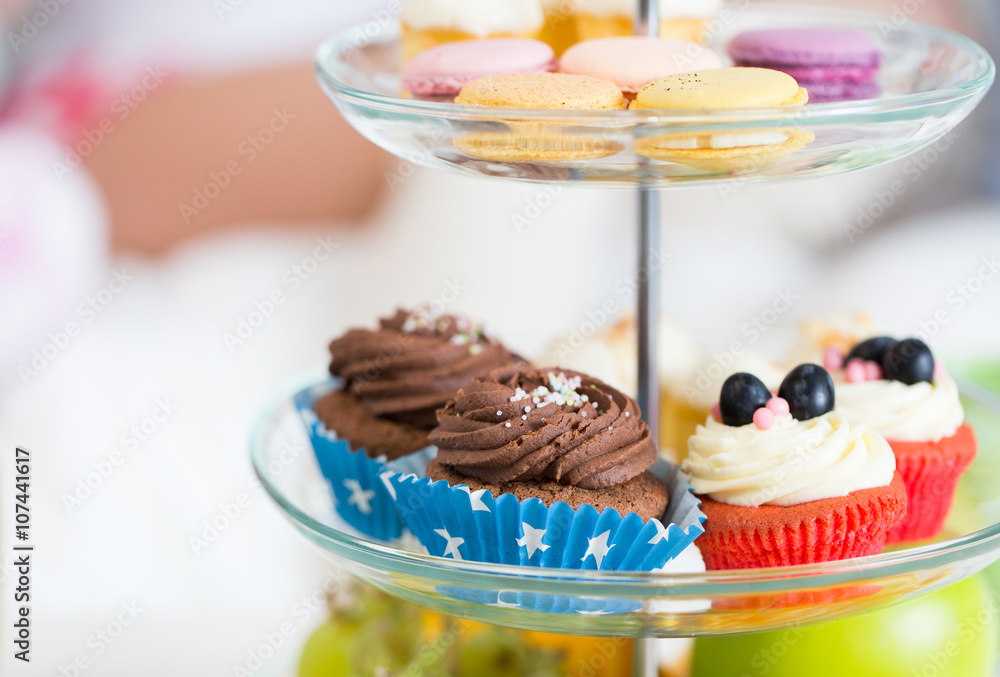 close up of cake stand with cupcakes and cookies - obrazy, fototapety, plakaty 