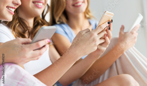 friends or teen girls with smartphones at home