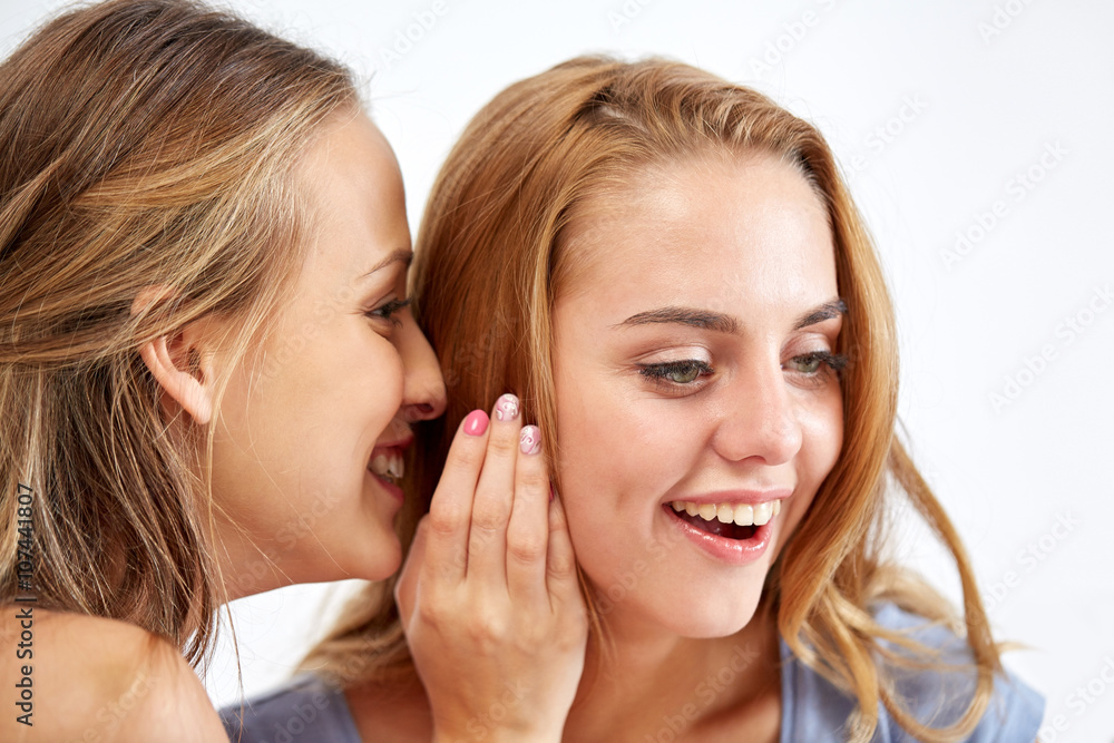 happy young women whispering gossip at home happy young women whispering gossip at home
