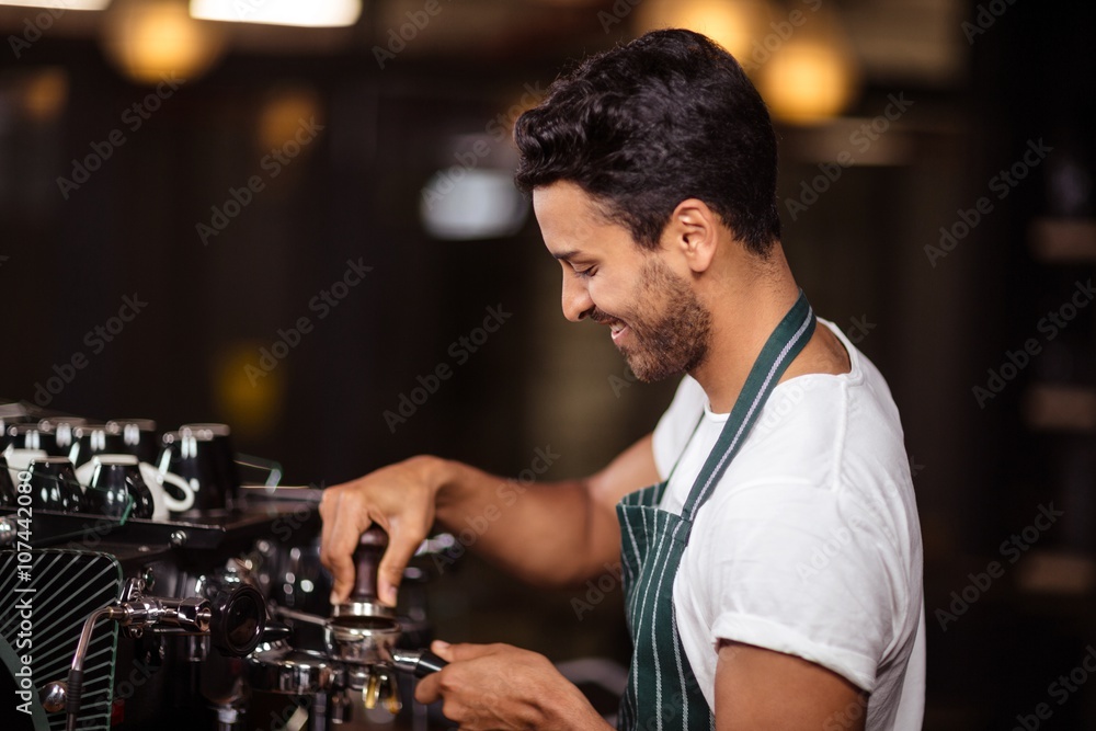 Smiling barista preparing coffee with a machine in a cafe Smiling barista preparing coffee with a machine in a cafe