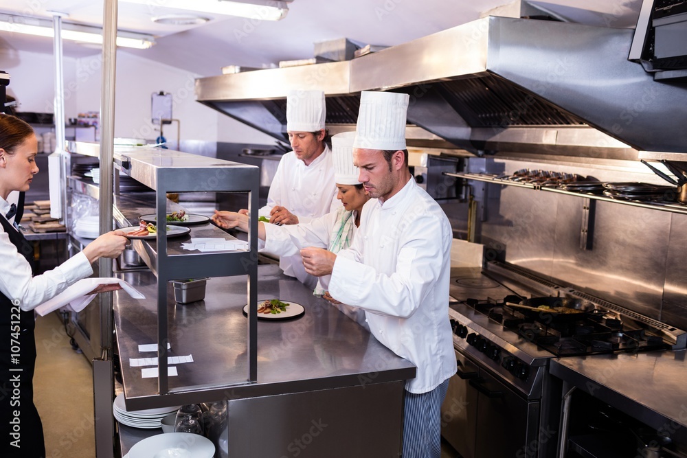 Group of chef preparing food in commercial kitchen Group of chef preparing food in commercial kitchen