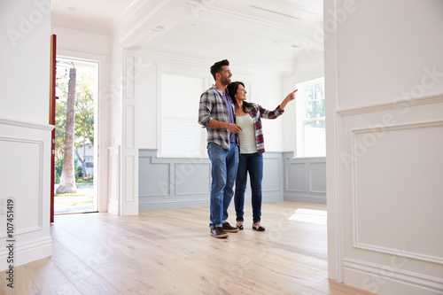 Fotografija Hispanic Couple Viewing Potential New Home