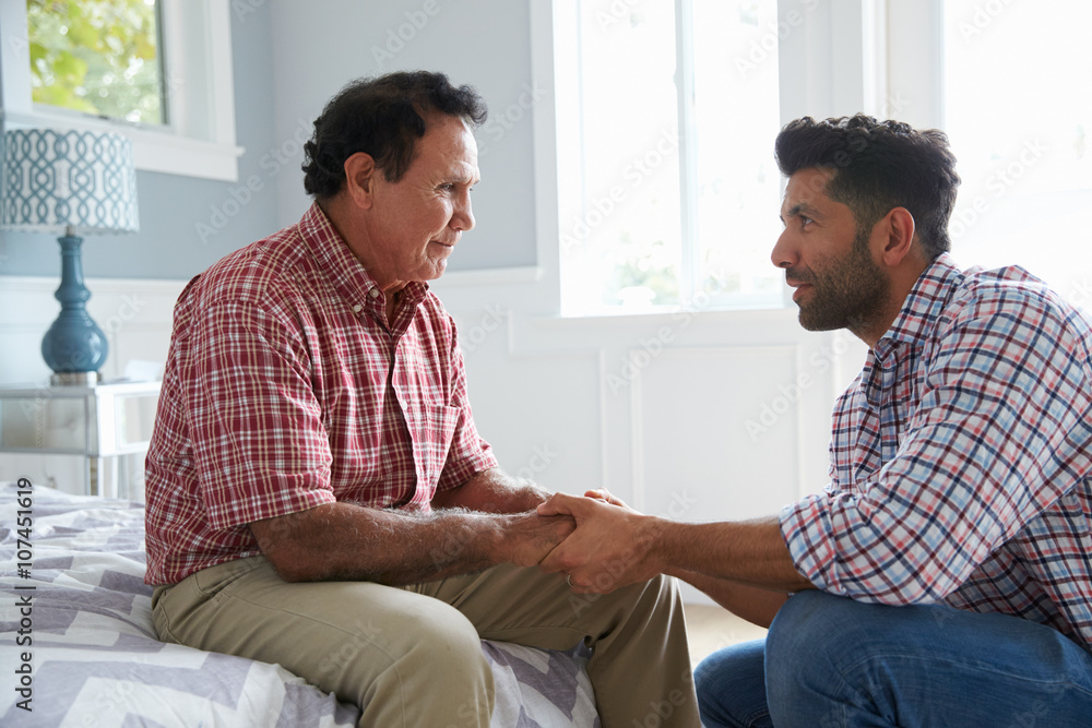 Obraz premium Adult Son Comforting Father Suffering With Dementia