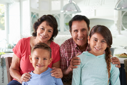 Hispanic Grandparents At Home With Grandchildren