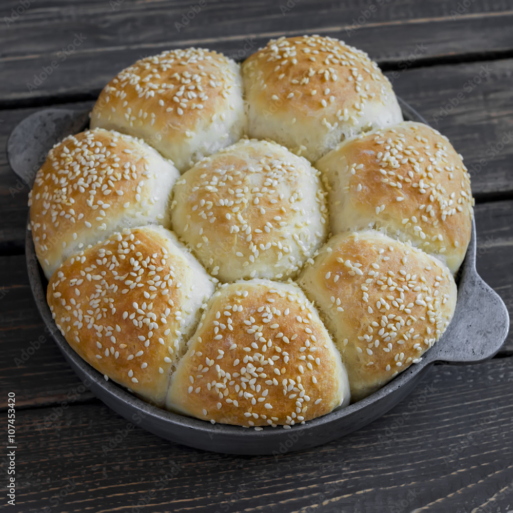 Homemade bread rolls in a vintage pan on wooden background