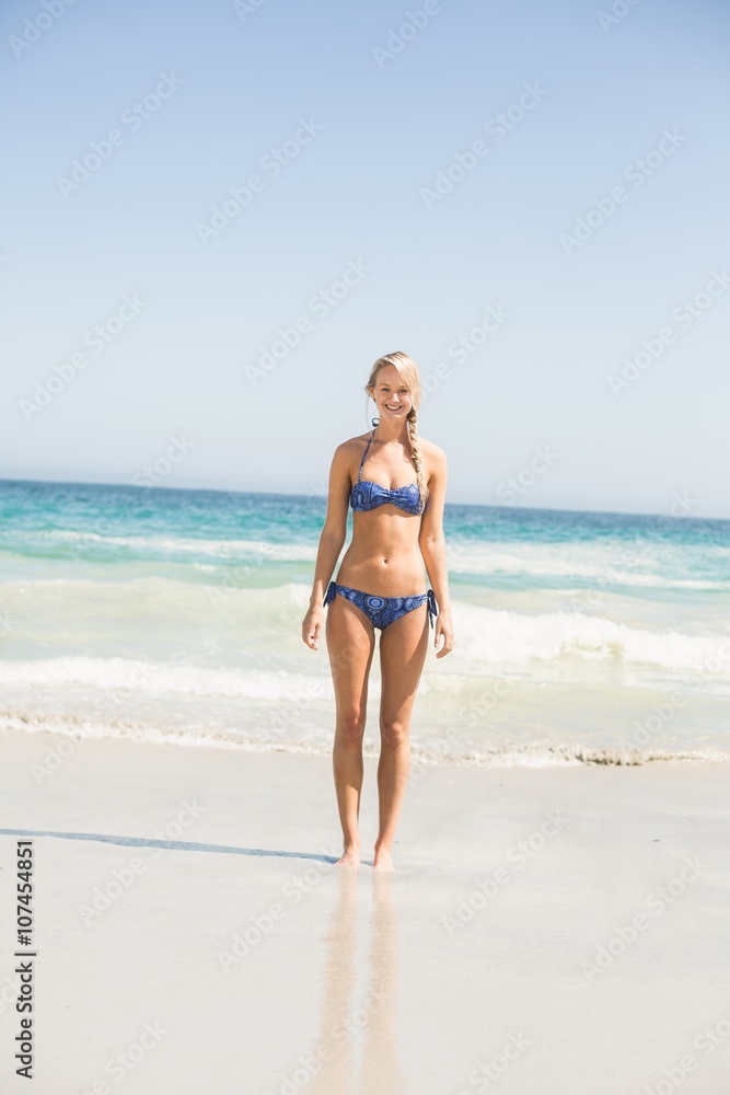 Happy woman in bikini standing on the beach