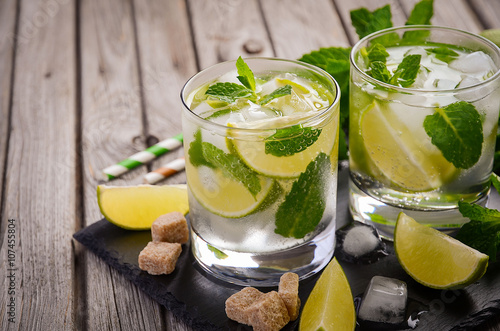 Fresh mojito cocktail with lime and mint on rustic wooden background © julijadmi