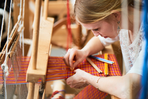 The girl in the production process of textiles are handmade on a loom photo