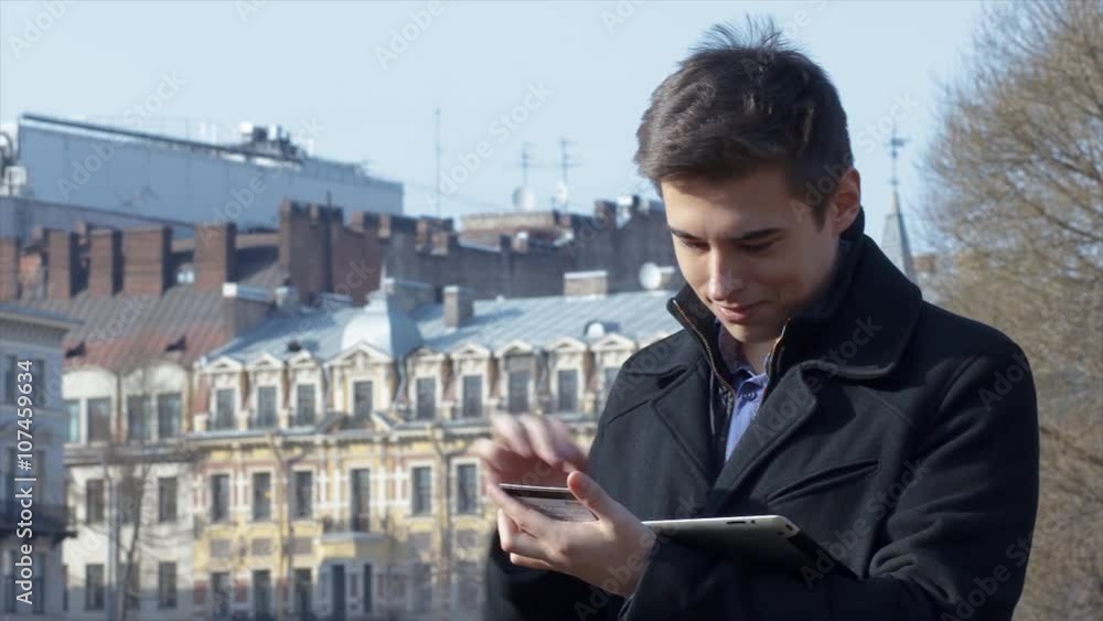 Man shopping online using tablet and credit card outside Man shopping online using tablet and credit card outside