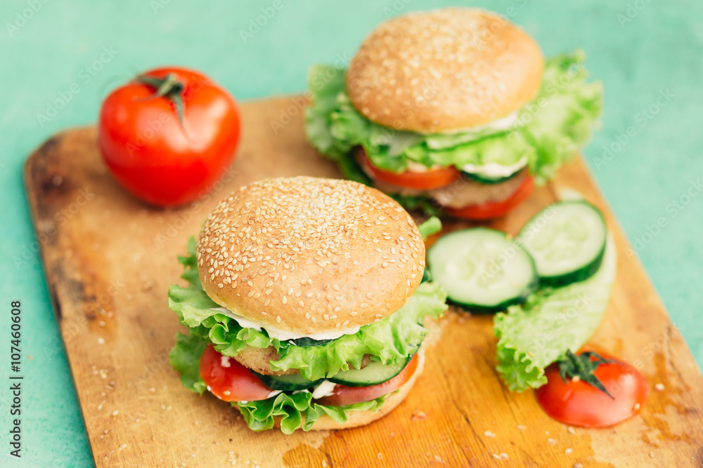 Home made burgers on wooden background Home made burgers on wooden background