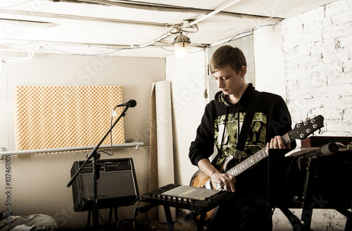 Caucasian man playing electric guitar in rock band photo