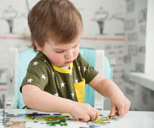 Obraz na płótnie Little boy playing puzzle w salonie