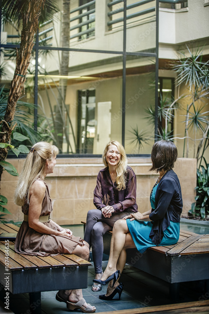 Businesswomen talking in office courtyard Businesswomen talking in office courtyard