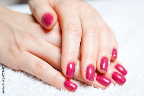Manicure in progress - Beautiful manicured woman s nails with red nail polish. The industry of beauty and nail care  beauty salons  soft focus
