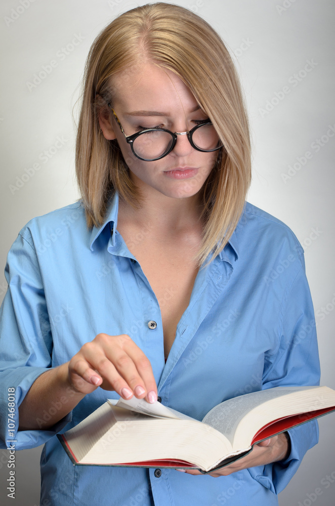 young pretty woman in glasses reading a book young pretty woman in glasses reading a book