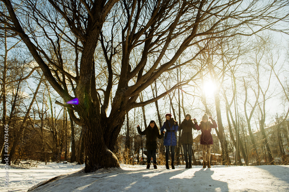 Caucasian girls standing neat tree in snowy field Caucasian girls standing neat tree in snowy field