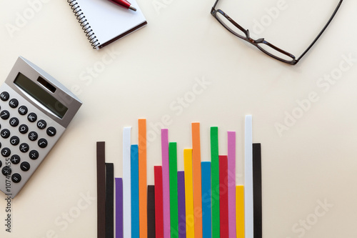 Glasses, calculator , notebook and graph colors on a light background