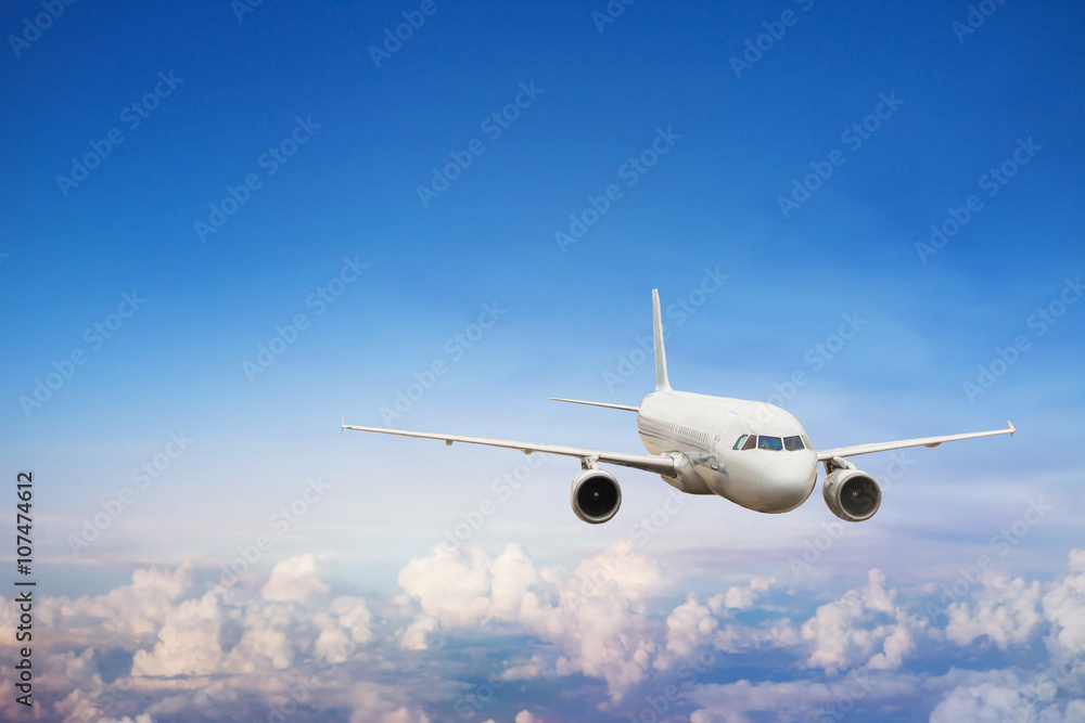 Fototapeta premium podróż samolotem, lot międzynarodowy, samolot lecący w błękitne niebo nad chmurami