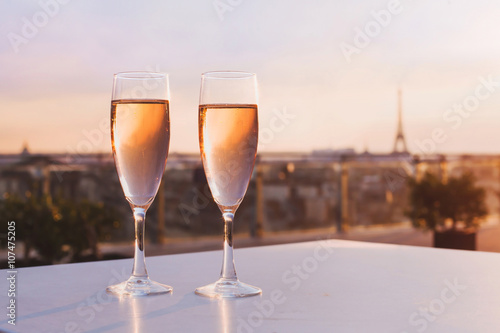 two glasses of champagne at rooftop restaurant with view of Eiffel Tower and Paris skyline, luxury romantic dinner for couple