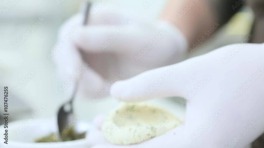 Cook in white gloves makes snacks. Cook in white gloves makes snacks.