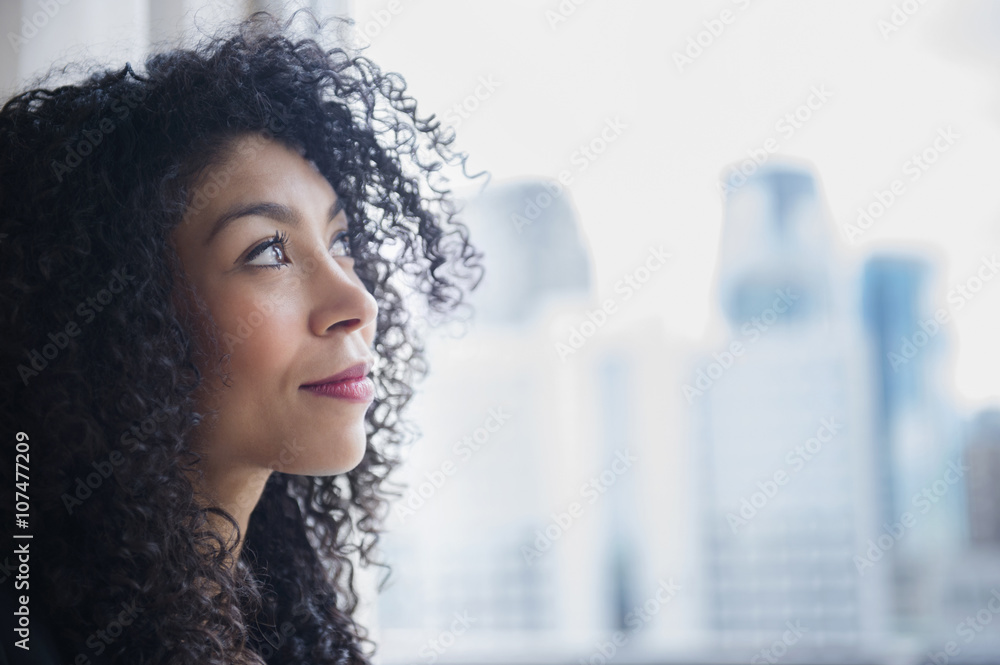 Mixed race businesswoman looking out window Mixed race businesswoman looking out window