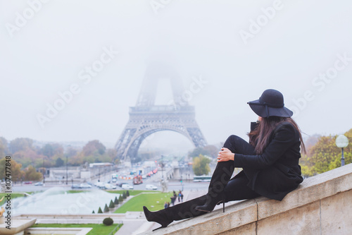 autumn and winter in Paris  fashion woman looking at Eiffel Tower in foggy day  France