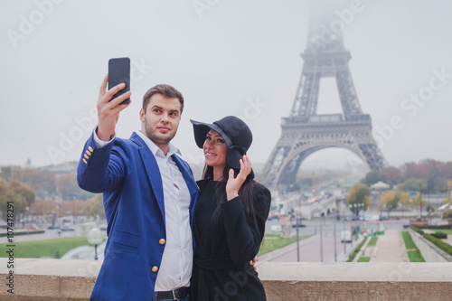 Photography couple of tourists taking photo with Eiffel Tower in Paris, selfie, tourism in E