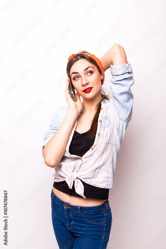 Portrait of a smiling attractive woman talking on the phone and looking at camera isolated on a white background Portrait of a smiling attractive woman talking on the phone and looking at camera isolated on a white background