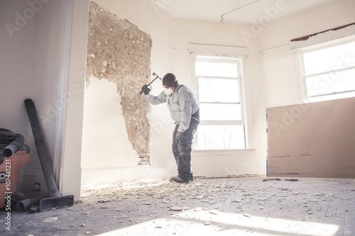Hispanic construction worker demolishing wall