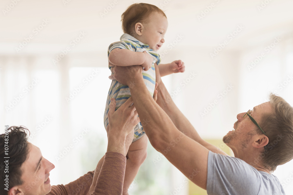 Caucasian gay fathers holding baby Caucasian gay fathers holding baby