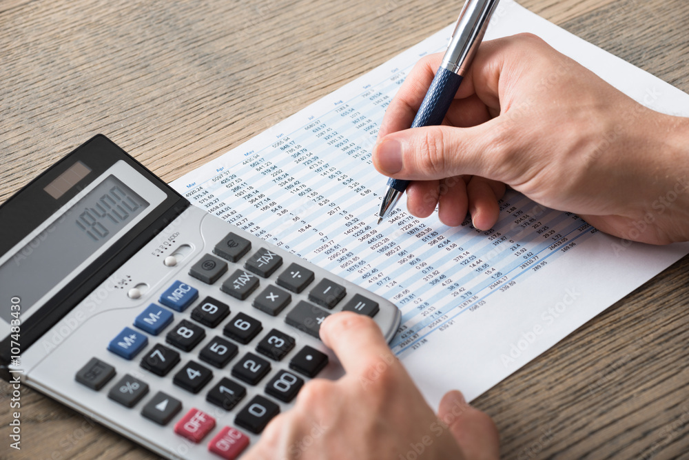 Businessman Analyzing Accounting Document With Calculator Businessman Analyzing Accounting Document With Calculator