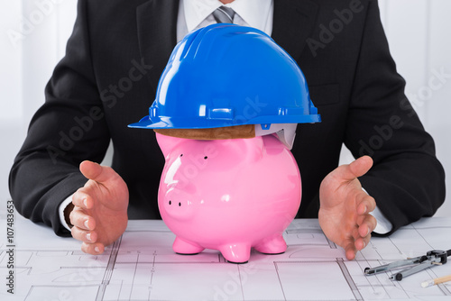 Architect Hands Protecting Piggybank Wearing Construction Helmet