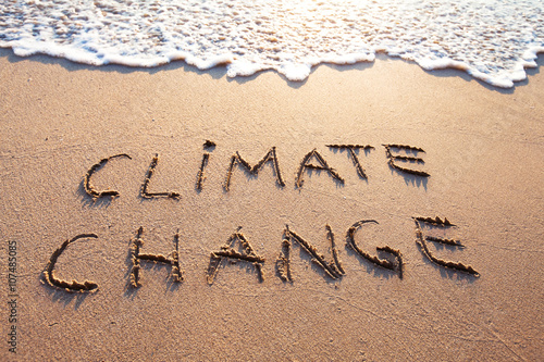 climate change concept, text written on the sand